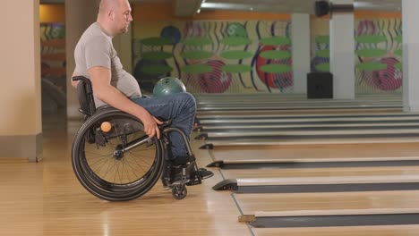 two young disabled men in wheelchairs playing bowling in the club