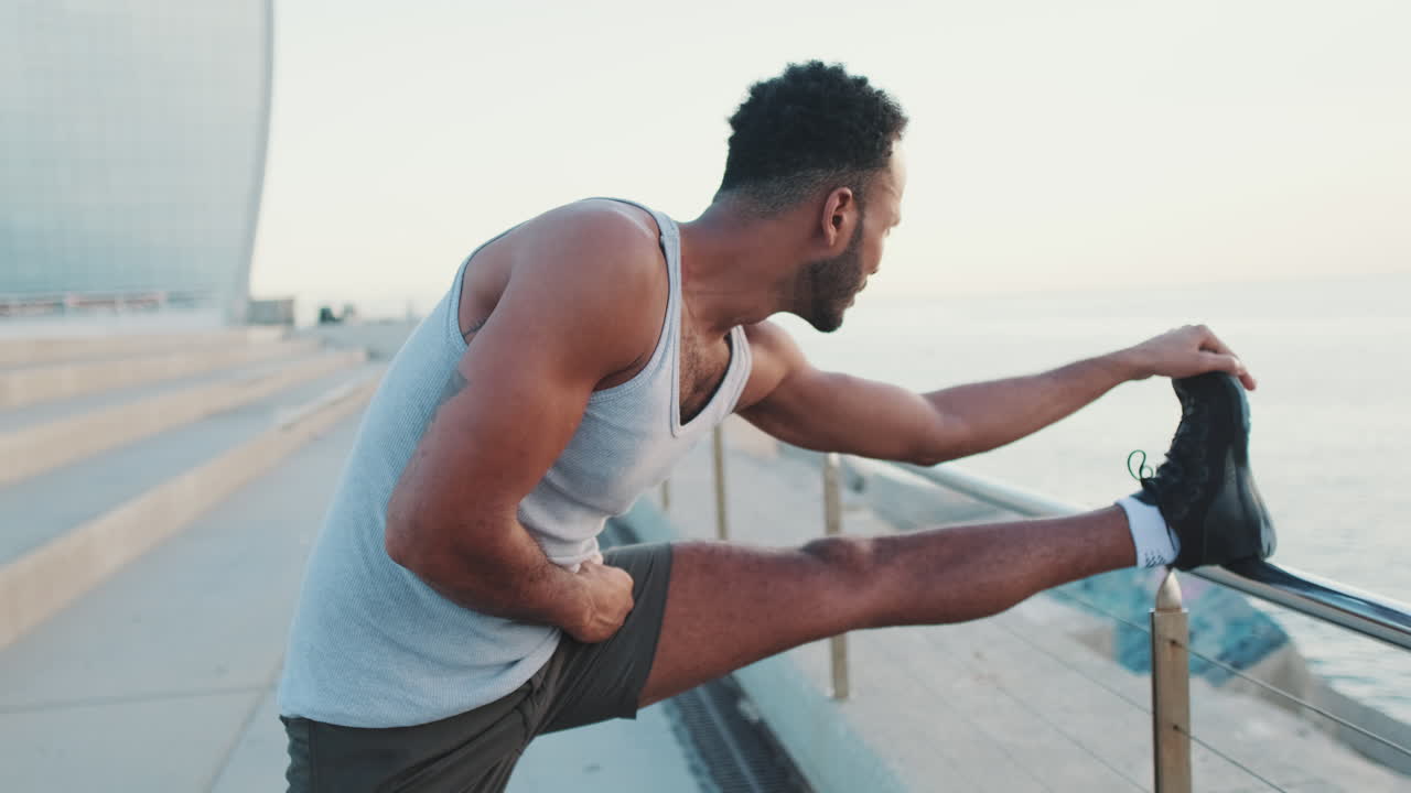Uomo che fa stretching all'aperto vicino all'oceano