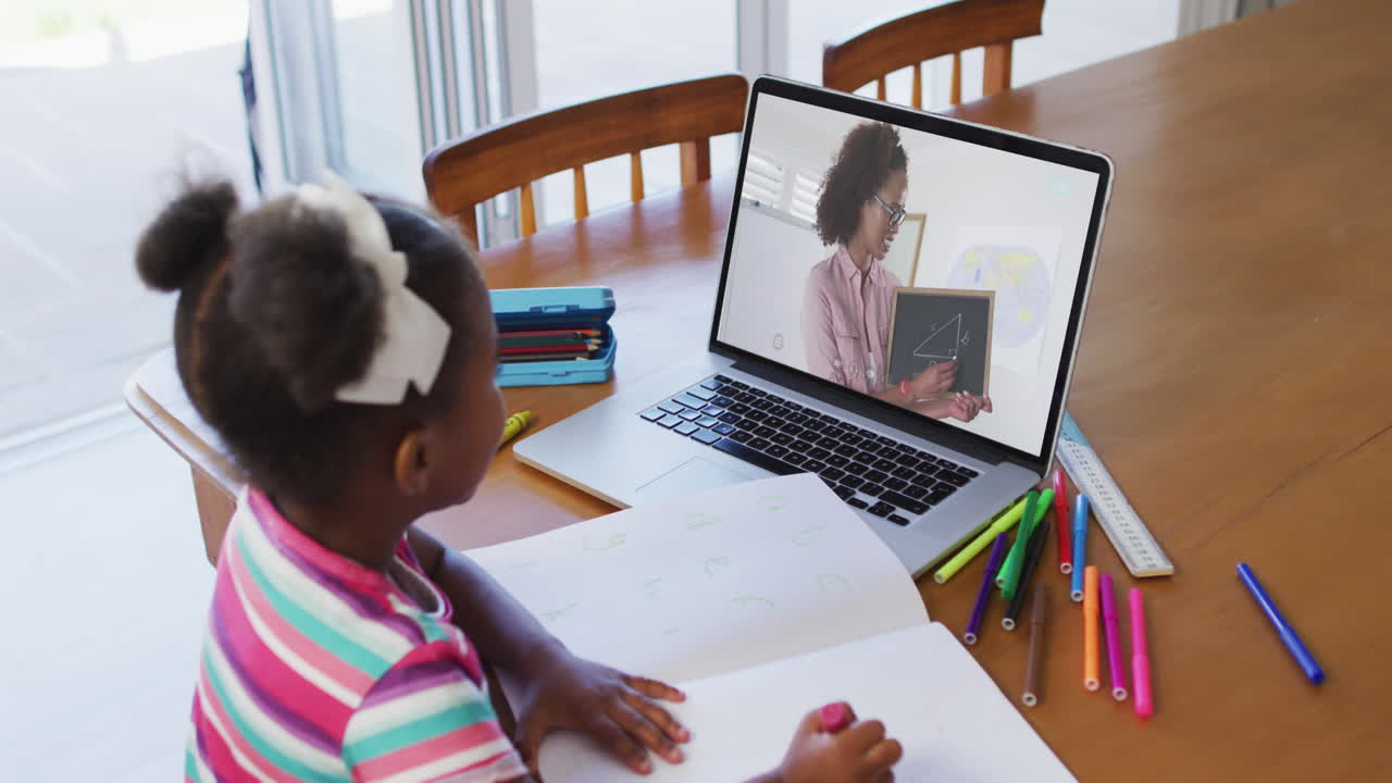 African american girl sitting at desk using laptop having online school lesson