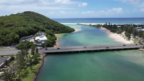 tallebudgera creek bridge with traveling vehicles in gold coast, queensland, australia - aerial drone shot