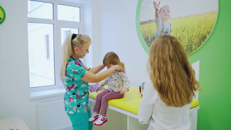 doctor examining little girl. throat sick little girl examined by pediatrician