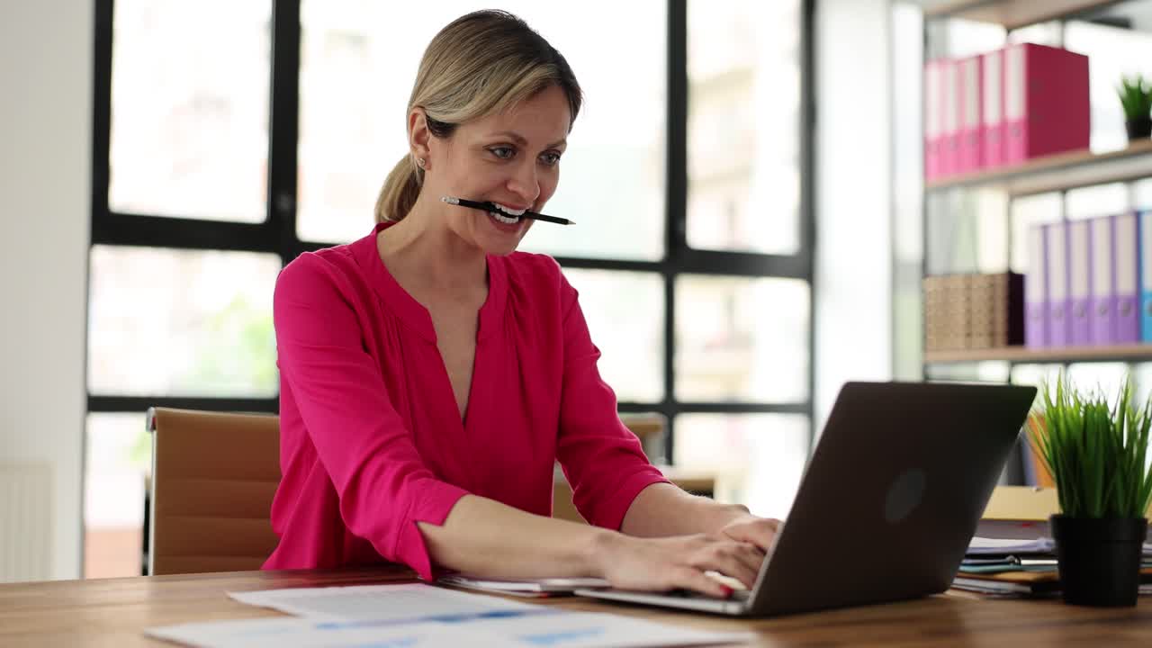 Woman working diligently on laptop in an office