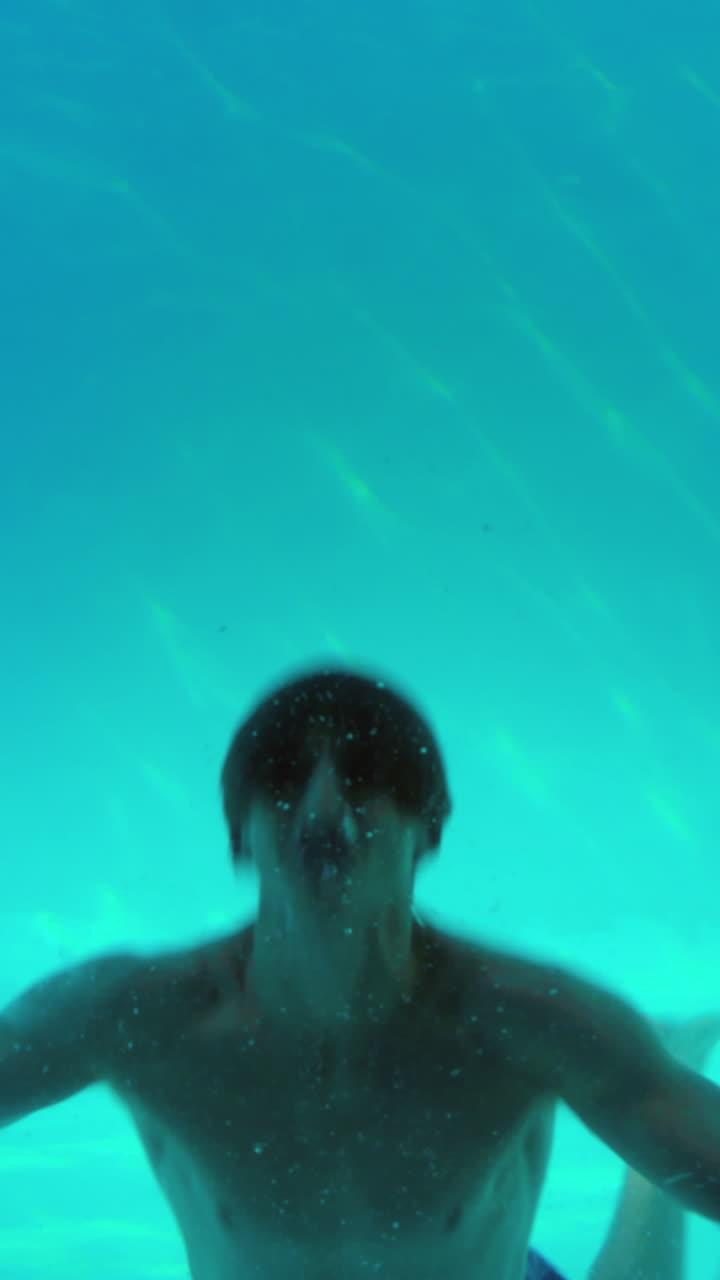 행복 한 사람 이 수영장 에 뛰어들어 카메라 를 흔들고 있다