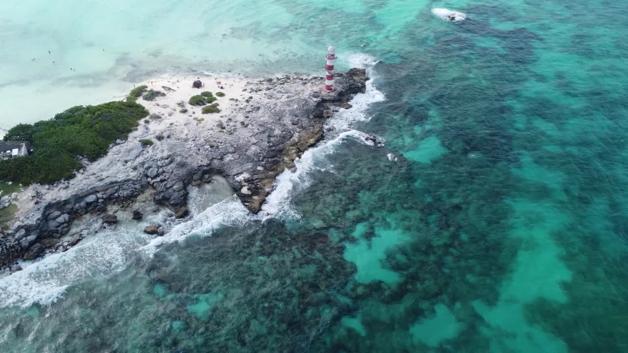 Aerial view of Caribbean Sea waves breaking on rocky coast of Vintage Lighthouse in Punta Cancun, Mexico