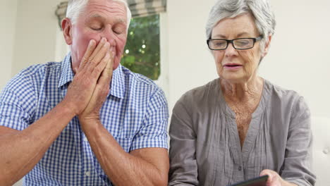 una pareja de ancianos pagando sus cuentas.