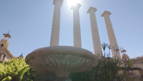 fountain near columns at museu nacional d'art de catalunya in daylight in barcelona. pan right, low angle view
