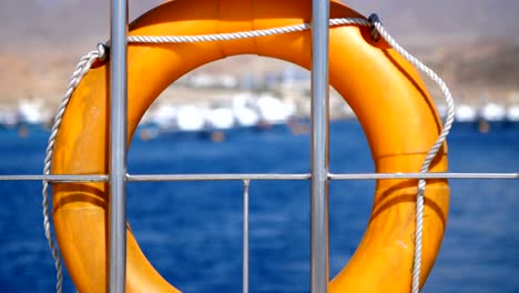 summer, sea, orange lifebuoy, hanging aboard a ferry, ship. special rescue equipment of the ship. saves the life of a person who is drowning