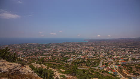 scenic viewpoint of a time-lapse over a city in cyprus with sweeping cirrus clouds and blue skies