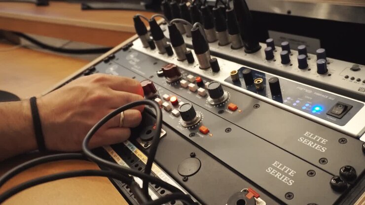 Cinematic close up of man hands adjusting knob levels in recording studio