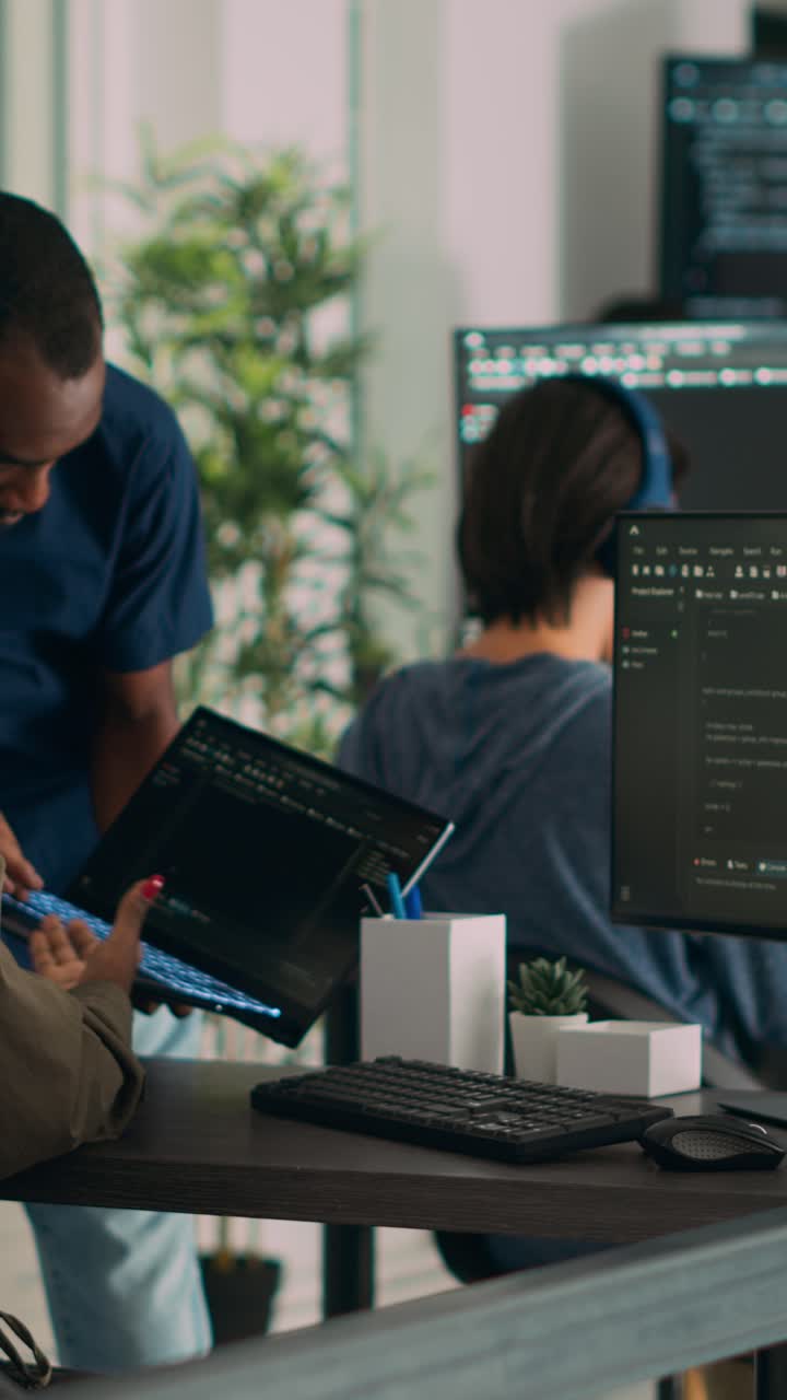 Vertical video: Database developer explaining algorithm to colleague coder pointing at running code