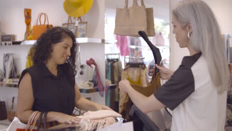 mujer latina alegre comprando ropa en la tienda de moda