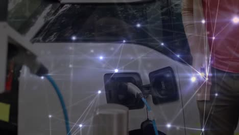 hombre cargando un coche eléctrico con una red de conexiones en movimiento