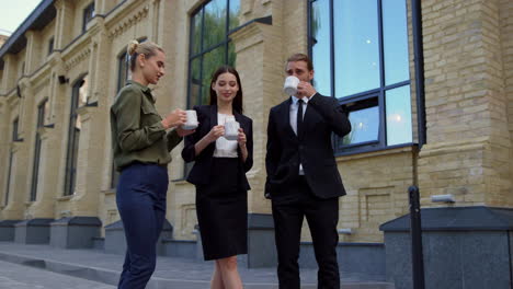 business people drinking coffee outside