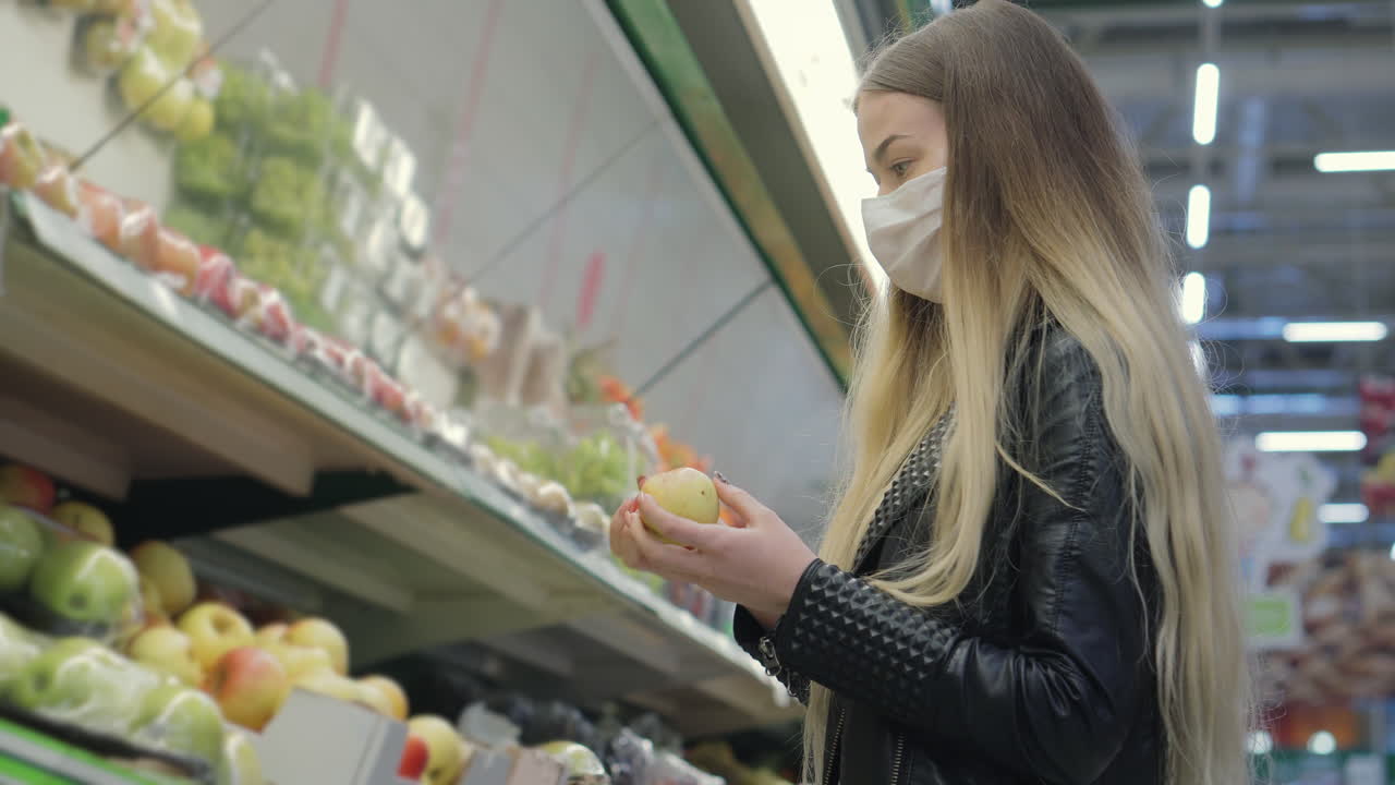 mujer comprando manzanas en una tienda de comestibles