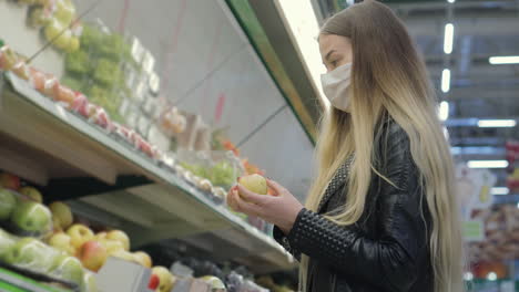 woman shopping for apples in a grocery store