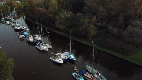 slow horizontal panning shot over boats on canal over tree