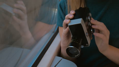 mujer usando una cámara de video retro para filmar el camino
