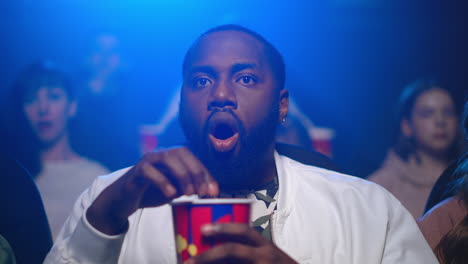 focused african man watching movie in cinema