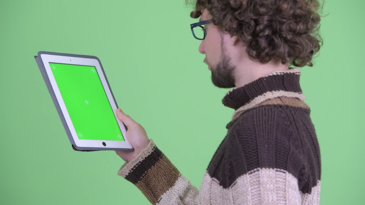 un joven guapo con barba y cabello rizado.