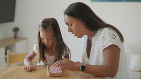 mother and daughter making a bracelet together