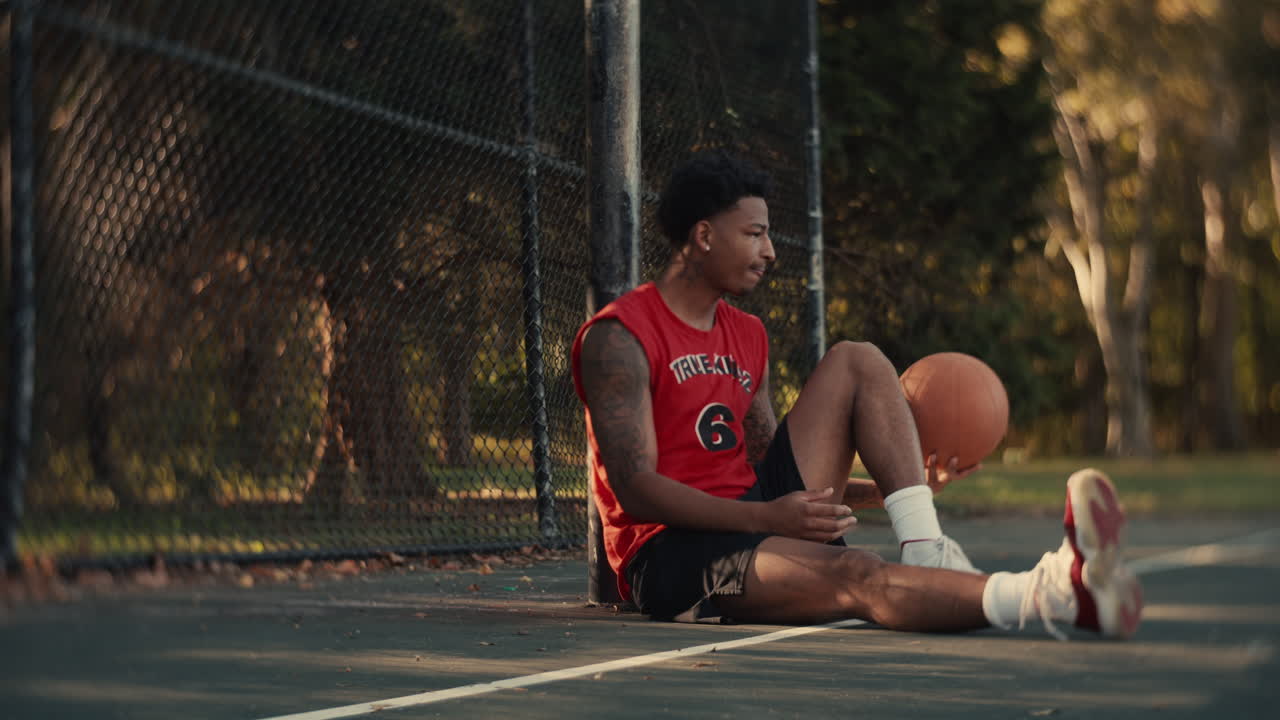 Basketball Player Sitting on Court