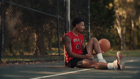 basketball player sitting on court