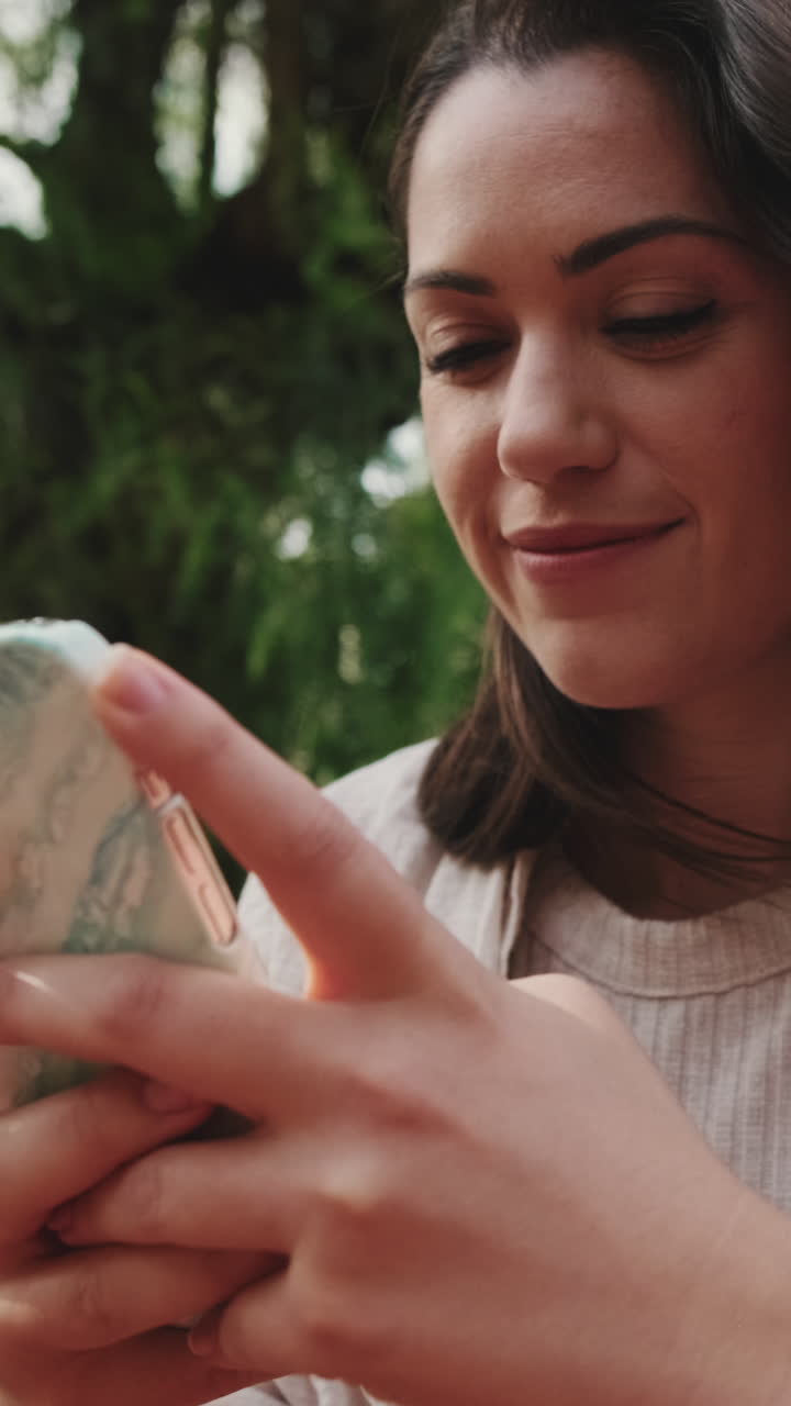 Giovane donna che usa il suo smartphone all'aperto