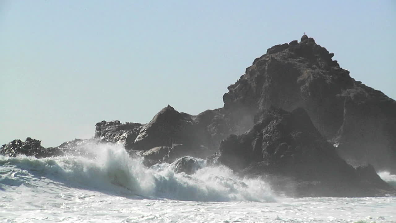 캘리포니아 해안선 1을 따라 화창한 날에 파도가 해안으로 밀려옵니다.
