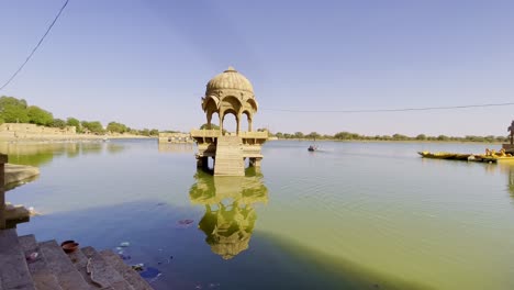 gadsisar lake in jaisalmer sparkles under the golden rajasthan sun, mirroring ancient temples, calm waters, and elegant pavilions offering a serene escape in the heart of the desert's timeless beauty.