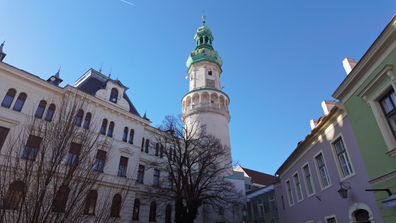 The Sopron Fire Tower seen from the back with the traditional houses of the old town surrounding it in Hungary.