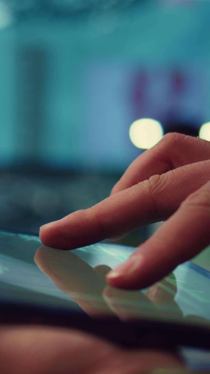 Primo piano di una mano che scorre e tocca lo schermo di un tablet digitale