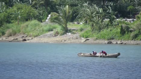 fishermen at river catching fish with net on their boay