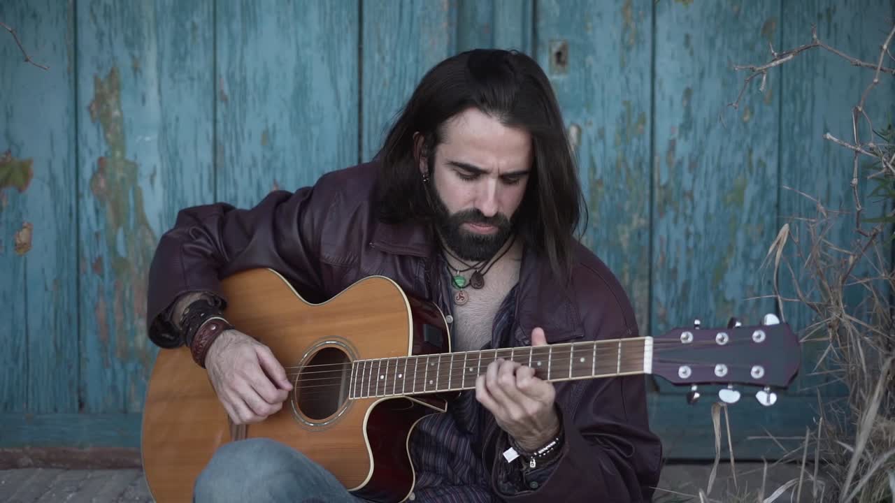 hombre tocando la guitarra acústica al aire libre