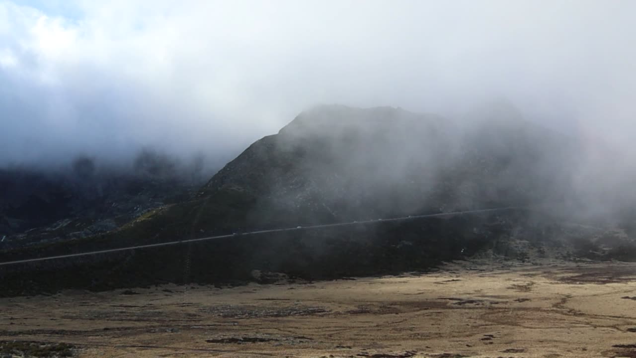 Driving Up Mountain in Serra da Estrela Natural Park Through Clouds With Another Road in Distance