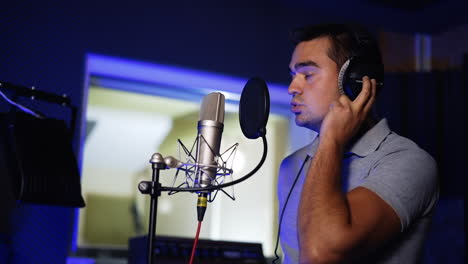 hombre cantando en un micrófono en un estudio de grabación