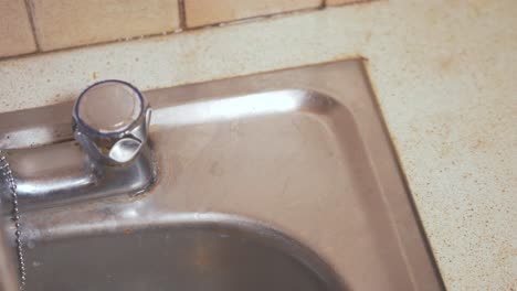 male hands grabbing a bar of natural homemade soap from kitchen sink