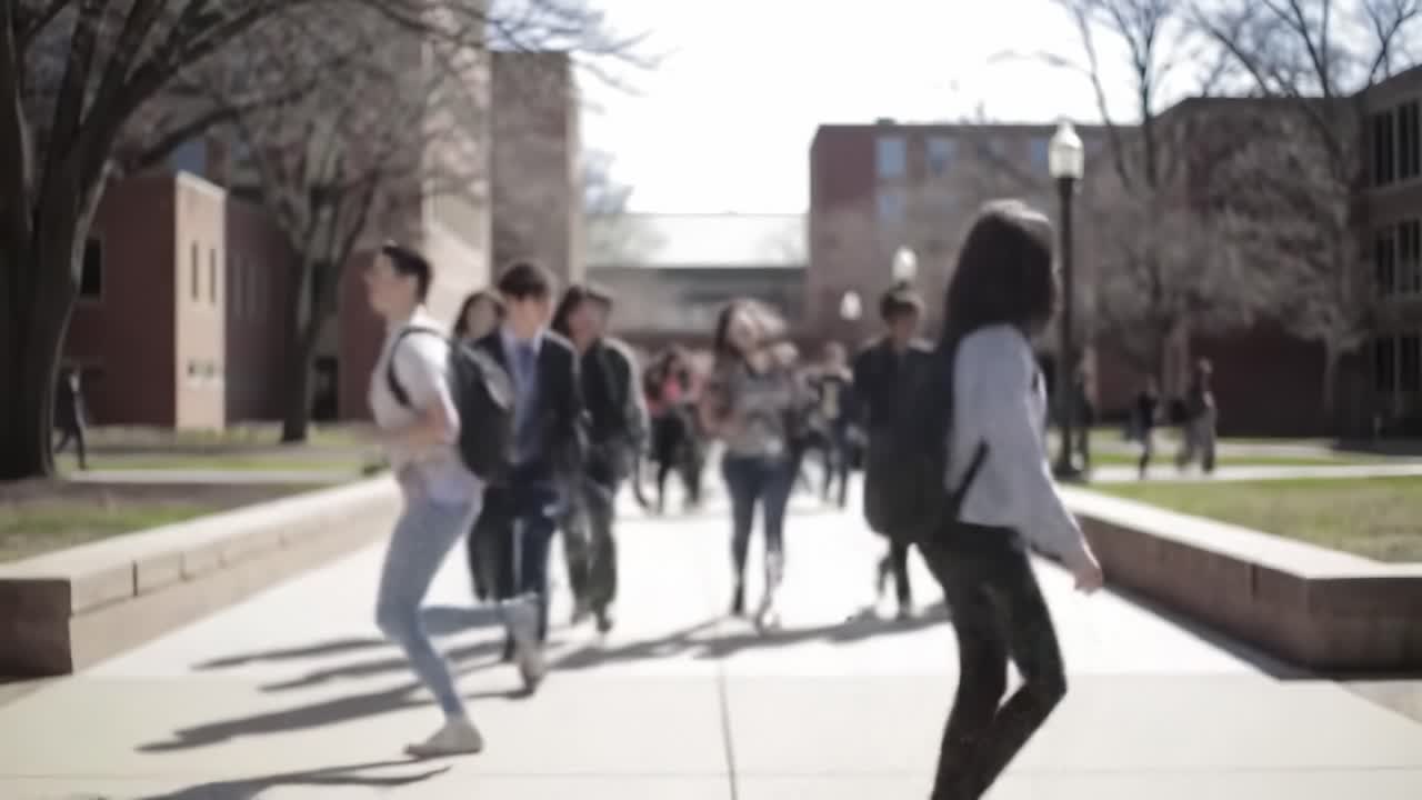 A Busy College Campus in Spring: Students Moving Between Classes in the Bright Sunlight, Creating a Vibrant Atmosphere of Learning and Social Interaction
