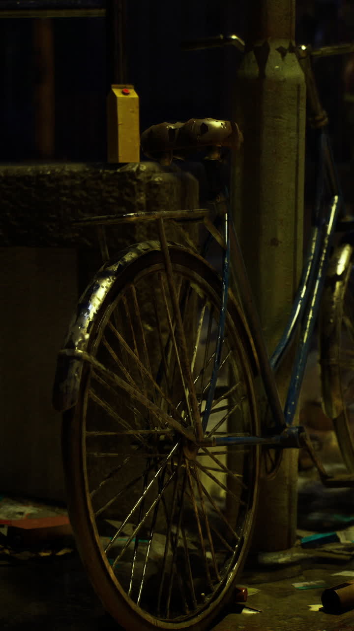Bicicletta parcheggiata vicino a un lampione con acqua a terra di notte.