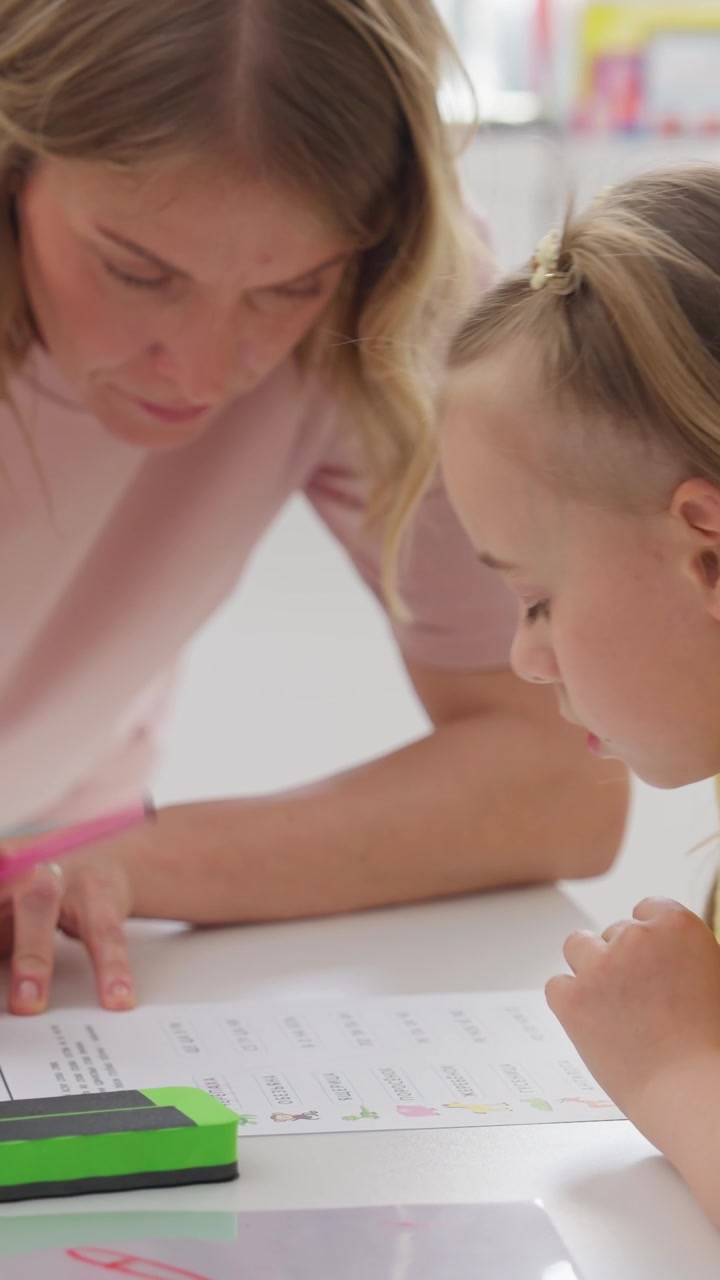 Donna adulta che aiuta una bambina con i compiti