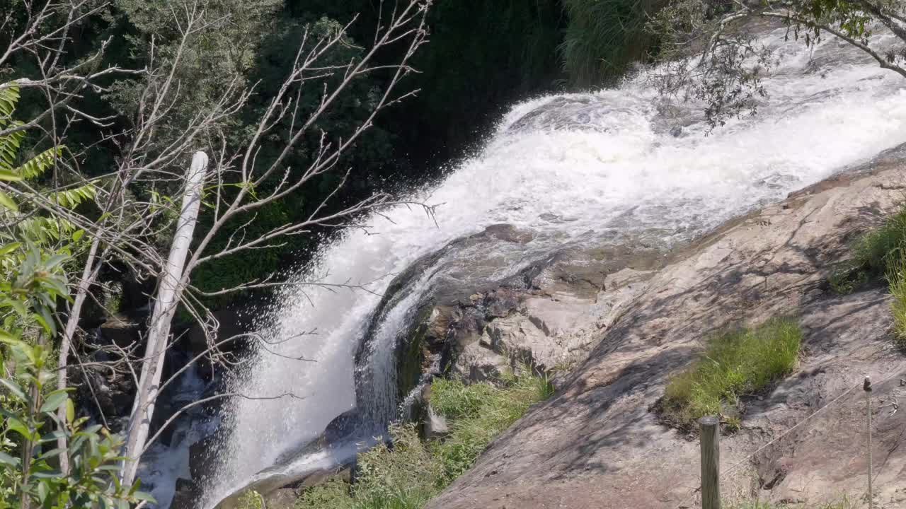 mirando hacia la cascada que fluye rápidamente sobre la superficie rocosa