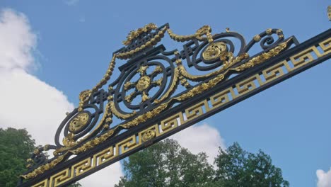 slow motion footage of a royal entrance to summer garden, saint-petersburg with golden elements, old ornaments, blue sky