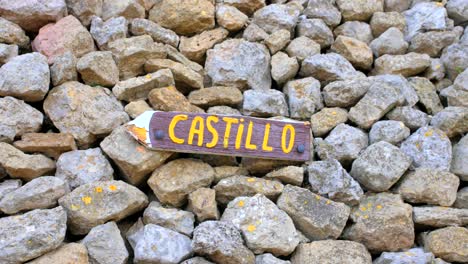 signo de flecha de madera con la palabra "castillo" en el montón de rocas