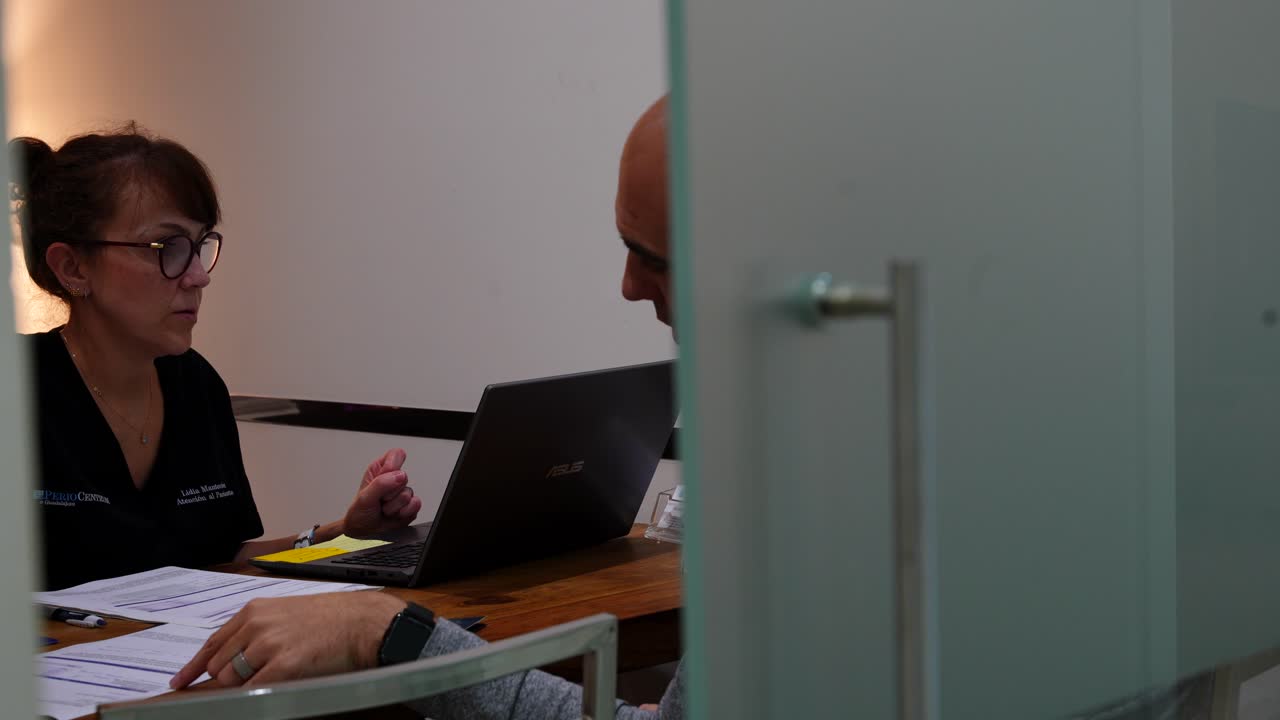 hombre calvo con un gesto preocupado mirando los resultados médicos en una clínica