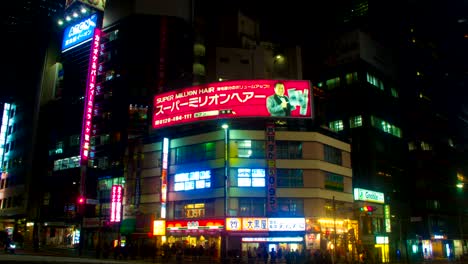 el lapso de la noche con los neones japoneses en el sur de shinjuku retrocede el obturador lento