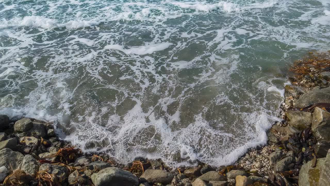 Onde infrante vicino alla costa, spinte dal moto ondoso e che si infrangono su fondali bassi vicino a affioramenti rocciosi, formando schiuma