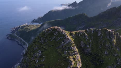 Summits-Reinebringen-mountain-range-against-blue-sea-on-summer-day,-Reine,-Norway---Aerial-orbiting