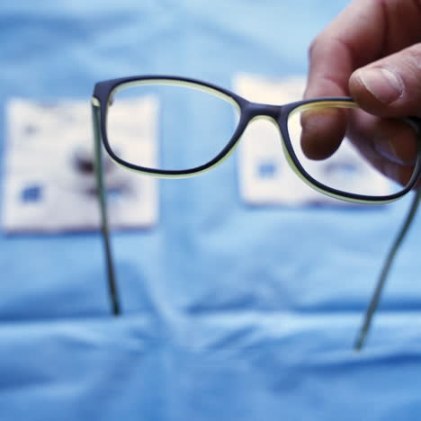 specialist puts lenses into black frame of eyeglasses. production of spectacles in the laboratory. making eyeglasses.