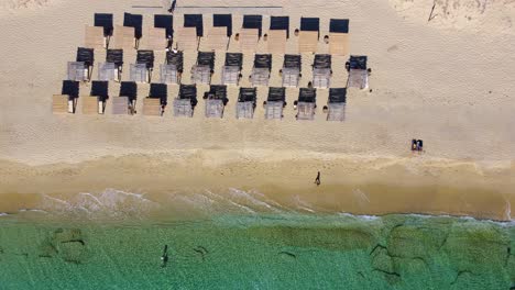 top view of quiet plaka beach with straw umbrellas, naxos, greece