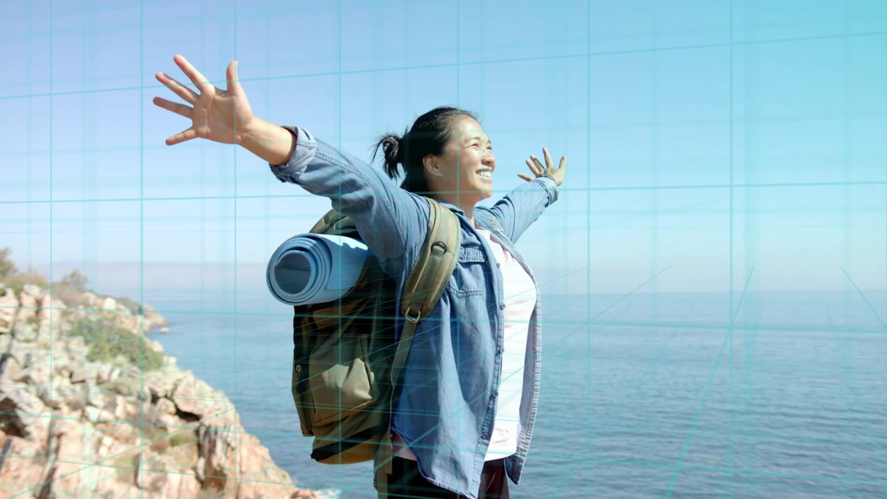 Donna escursionista che raggiunge la scogliera, alzando le braccia in una posa aperta di fronte all'oceano, con zaino e griglia che indica lo stato di salute