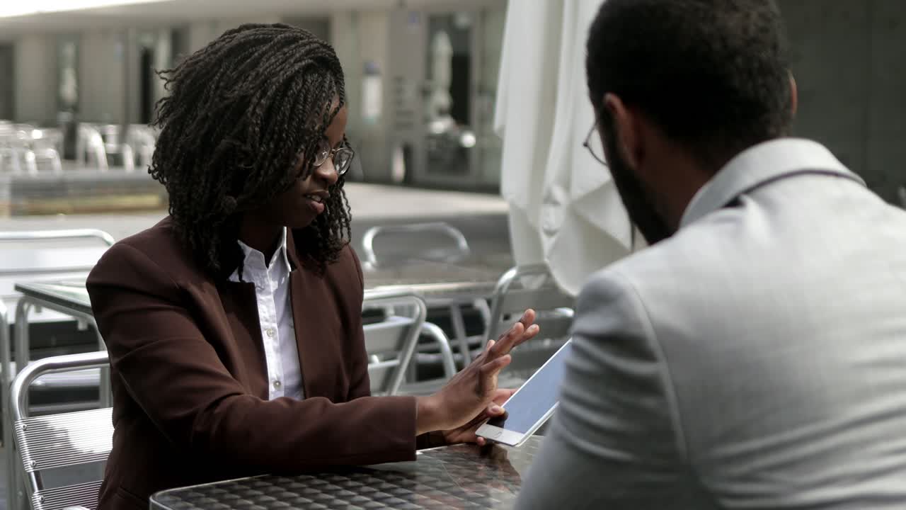 Serious business partners talking at outdoor cafe.